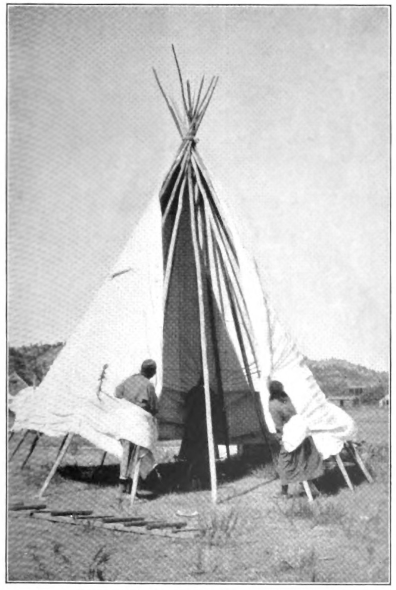 Two women setting up a teepee